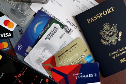 Passaporte, cartões e cartão de embarque dispostos sobre uma superfície, representando viagens e créditos de fidelidade.