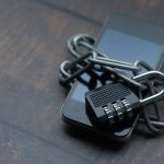 Smartphone envolto por uma corrente com cadeado, simbolizando segurança e proteção digital.