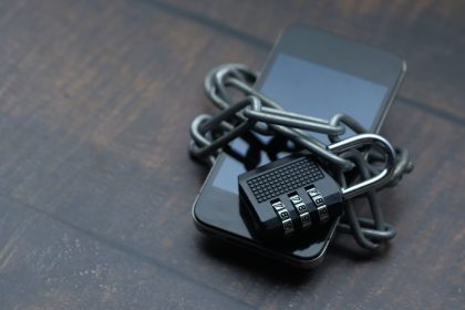 Smartphone envolto por uma corrente com cadeado, simbolizando segurança e proteção digital.