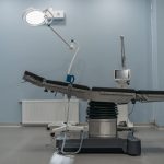 Sala de cirurgia vazia, com mesa operatória e equipamentos médicos modernos.