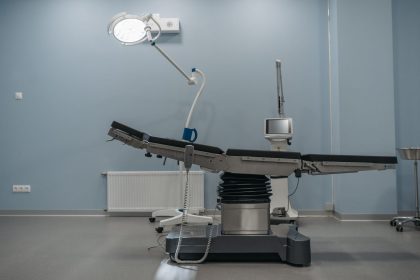 Sala de cirurgia vazia, com mesa operatória e equipamentos médicos modernos.
